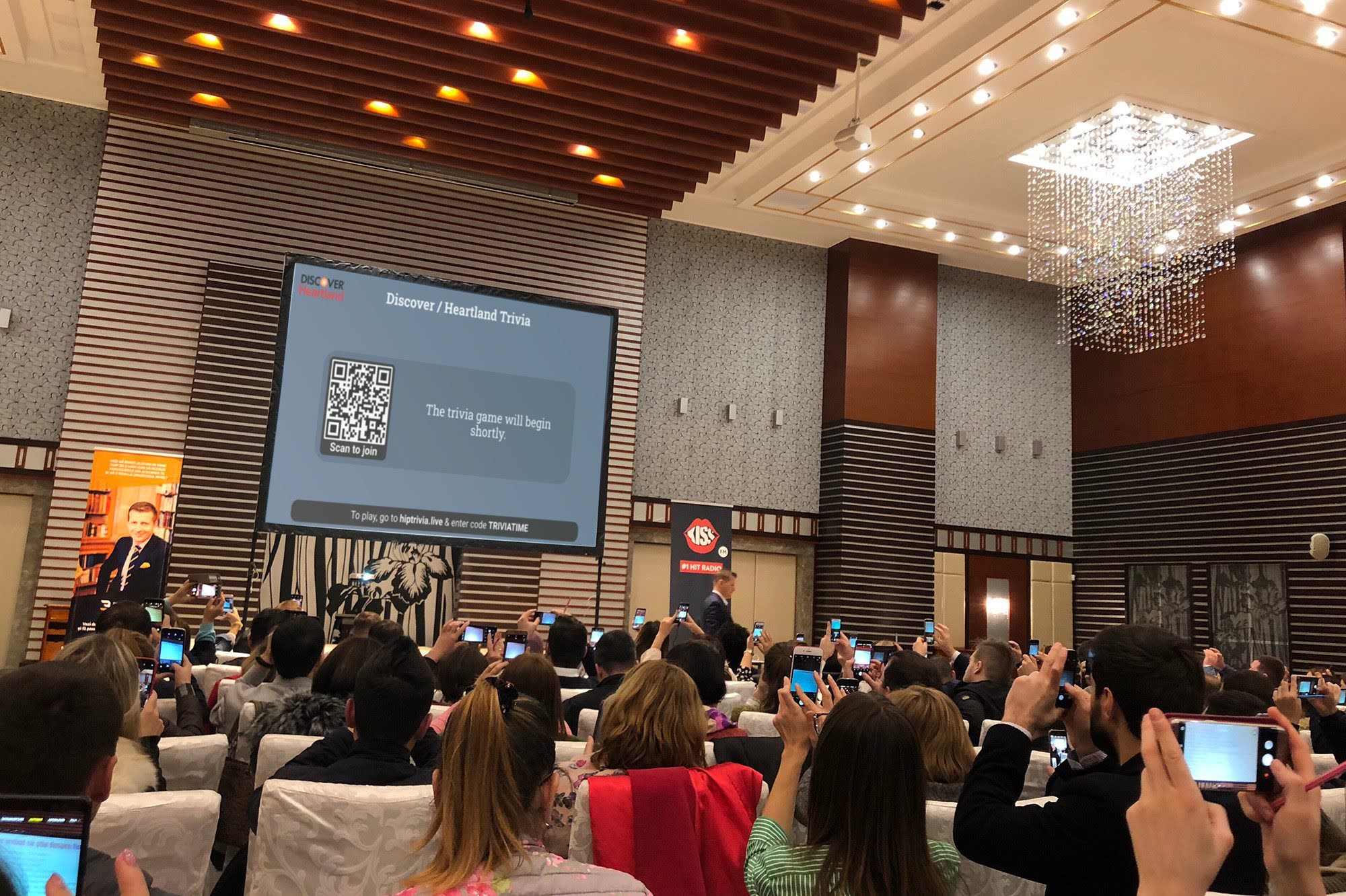 An entire conference audience holding up phones to join the game